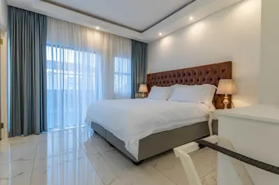 a bedroom with a large bed and a large window at Oceanway Boutique Hotel/Conference in Cape Town