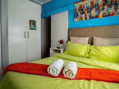 a bedroom with two towels on a bed at Relaxing Guest House in the Heart of Ndabeni in Cape Town