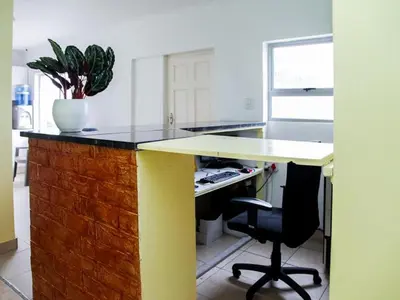 a kitchen with a desk with a potted plant at Relaxing Guest House in the Heart of Ndabeni in Cape Town