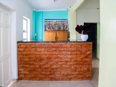 a brick wall in a room with a painting on the wall at Relaxing Guest House in the Heart of Ndabeni in Cape Town