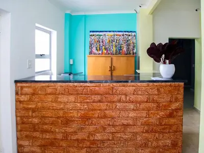 a brick counter in a room with a painting on the wall at Relaxing Guest House in the Heart of Ndabeni in Cape Town