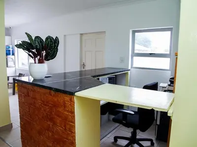 an office with a desk with a potted plant on it at Relaxing Guest House in the Heart of Ndabeni in Cape Town