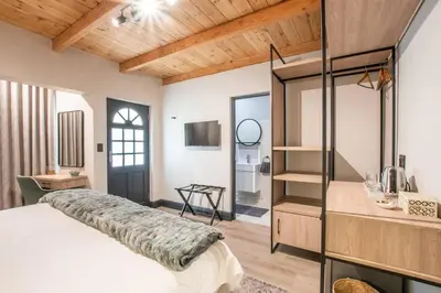 a bedroom with a large bed and a glass wall at Eikenhof Estate in Brackenfell