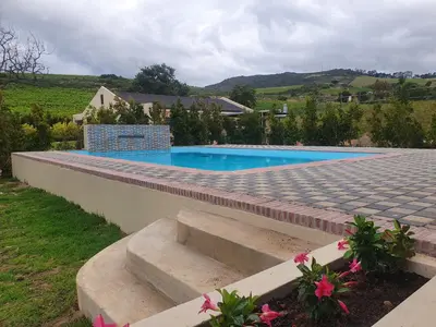 a swimming pool with steps next to a house at Eikenhof Estate in Brackenfell