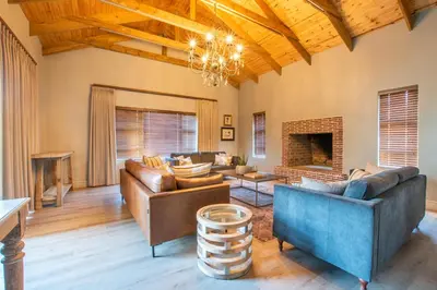 a living room with leather furniture and a fireplace at Eikenhof Estate in Brackenfell
