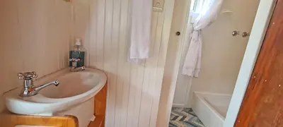 a bathroom with a sink and a bath tub at Little Haven 10 & 12 in Hermanus