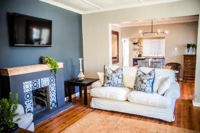 a living room with a white couch and a fireplace at Seven on Flora- Hot Tub, Modern with amazing outside area in Hermanus