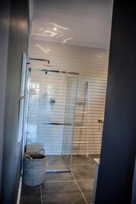 a shower with a glass door in a bathroom at Seven on Flora- Hot Tub, Modern with amazing outside area in Hermanus