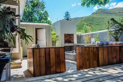 a backyard with a wooden fence and a tub at Seven on Flora- Hot Tub, Modern with amazing outside area in Hermanus