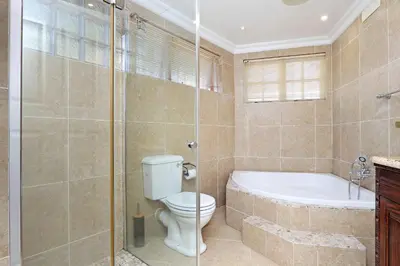 a bathroom with a toilet and a bath tub at The Bohemian Guesthouse in Cape Town