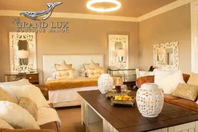 a large living room with a bed and a table at Grand Lux Boutique Manor in Hermanus