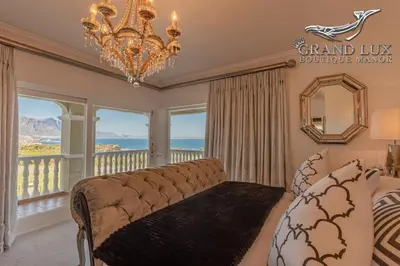 a living room with a couch and a chandelier at Grand Lux Boutique Manor in Hermanus