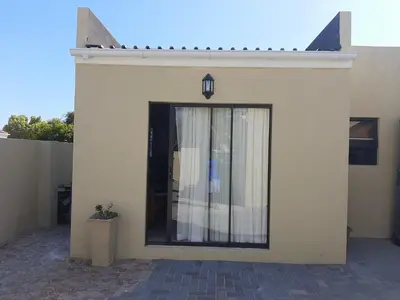 a white building with a glass door on it at Shalom Self catering in Cape Town