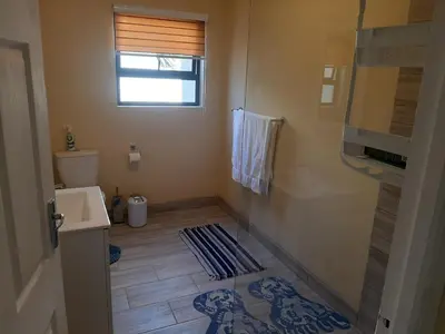 a small bathroom with a toilet and a sink at Shalom Self catering in Cape Town