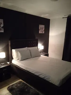 a bedroom with a large white bed with two lamps at ILITHA PARK in Cape Town