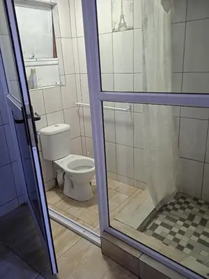 a bathroom with a toilet and a glass door at ILITHA PARK in Cape Town