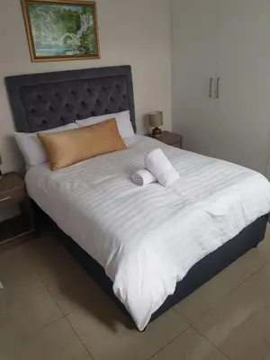 a large white bed with two pillows on it at izuba Lodge in Cape Town