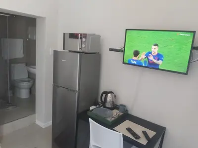 a television hanging on a wall in a kitchen at izuba Lodge in Cape Town