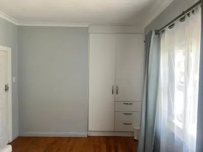 a room with white cabinets and a window at izuba Lodge in Cape Town