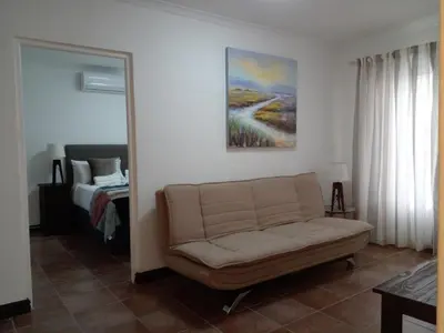 a living room with a couch and a bed at Sikelela Guest House in Cape Town