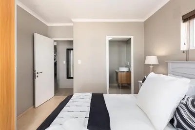 a bedroom with a large white bed and a bathroom at Horizon Bay 301 by CTHA in Bloubergstrand