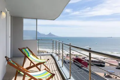 two chairs on a balcony with a view of the beach at Horizon Bay 301 by CTHA in Bloubergstrand