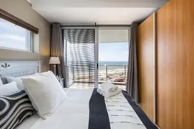 a bedroom with a bed with a view of the ocean at Horizon Bay 301 by CTHA in Bloubergstrand