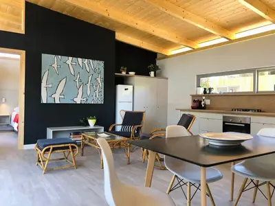 a kitchen and dining room with a table and chairs at Palm and Pine Cottage in Cape Town
