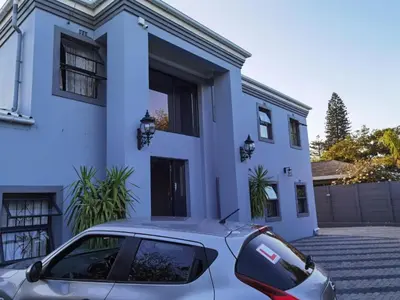 a car parked in front of a white house at Victoria Guest Lodge in Bellville