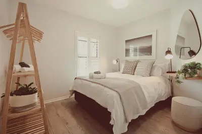 a white bedroom with a bed and a mirror at Luxury on Dorp in Stellenbosch