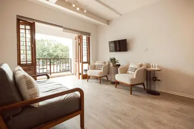 a living room with a couch and chairs and a balcony at Luxury on Dorp in Stellenbosch