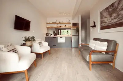a living room with a couch and chairs and a kitchen at Luxury on Dorp in Stellenbosch