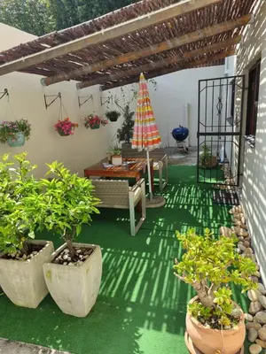 a patio with potted plants and a table and umbrella at Barlinka lane Selfcatering flatlet , Somerset West in Cape Town
