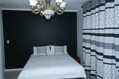 a bedroom with a bed and a chandelier at Tia Maria House in Cape Town