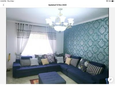 a living room with a blue couch and a window at Tia Maria House in Cape Town