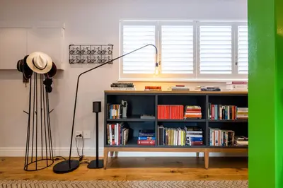 a living room with a book shelf and a lamp at Luxury Apartments - Rozenhof Villa in Stellenbosch