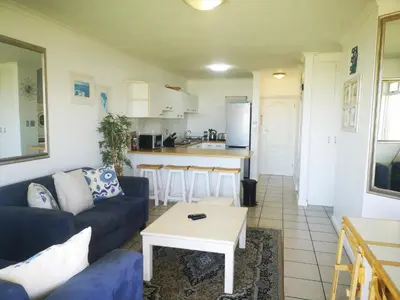 a living room with a couch and a table at Cape Town Family Beachfront Apartment Leisure Bay in Cape Town