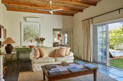 a living room with a couch and a table at Tockie's Cottage in Franschhoek