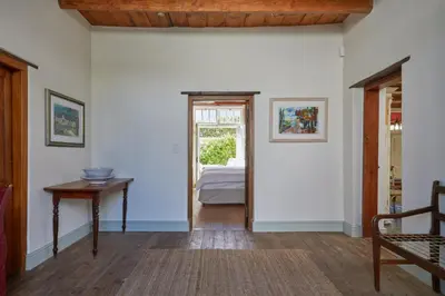a hallway with a door leading to a bedroom at Tockie's Cottage in Franschhoek