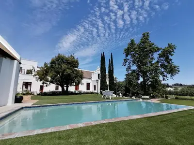 a swimming pool in the yard of a house at Avontuur Manor House and Wine Estate in Somerset West