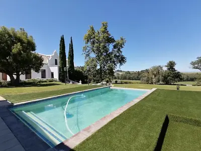a swimming pool in the yard of a house at Avontuur Manor House and Wine Estate in Somerset West