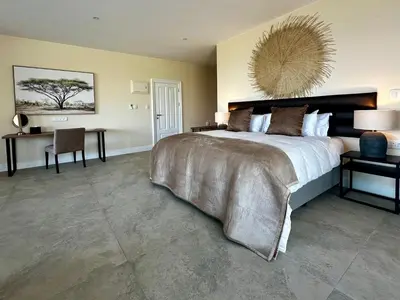 a large bedroom with a large bed and a desk at Cape Vermeer in Somerset West
