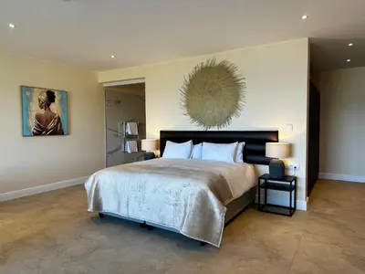 a bedroom with a large bed and a painting on the wall at Cape Vermeer in Somerset West