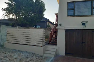 a house with a fence and a basketball hoop on the door at Upstairs in Cape Town