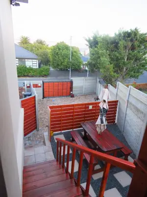 a woman standing on a bench on a patio at Upstairs in Cape Town