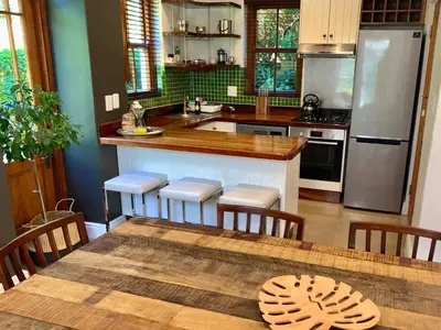 a kitchen with a table with chairs and a counter top at The Guardian Hermanus Luxury Self-Catering Hemel en Aarde Valley in Hermanus