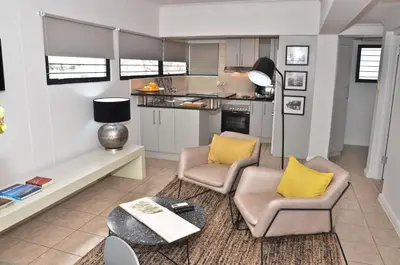 a living room with two chairs and a table at Concord Modern Apartment in Stellenbosch in Stellenbosch