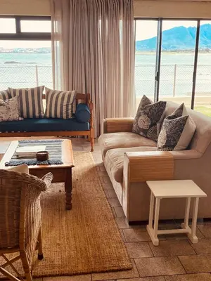 a living room with a couch and a table at By Die See in Gordonʼs Bay