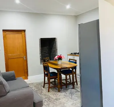 a living room with a table and a couch at Bonne Chance Cottage in Paarl