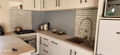 a kitchen with white cabinets and a sink at Little Willow Brooke in Franschhoek